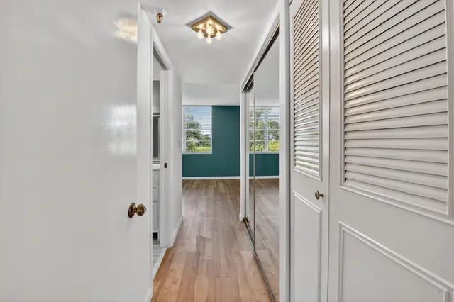 a view of a hallway with wooden floor and staircase