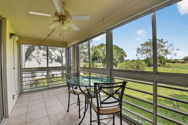 a dining room with furniture water view and a floor to ceiling window