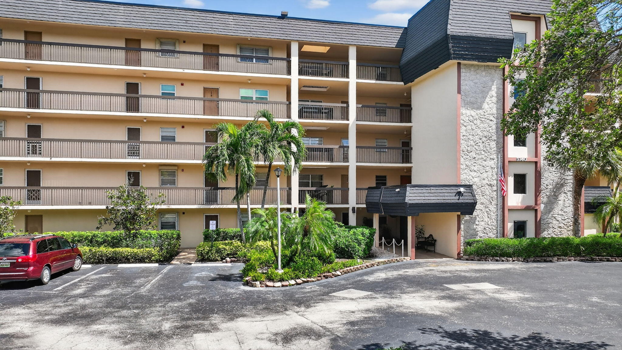 5340 Northwest 2nd Avenue, Unit 220 Boca Raton, FL 33487 - Photo 41 of 46 a front view of a building with a garden and plants