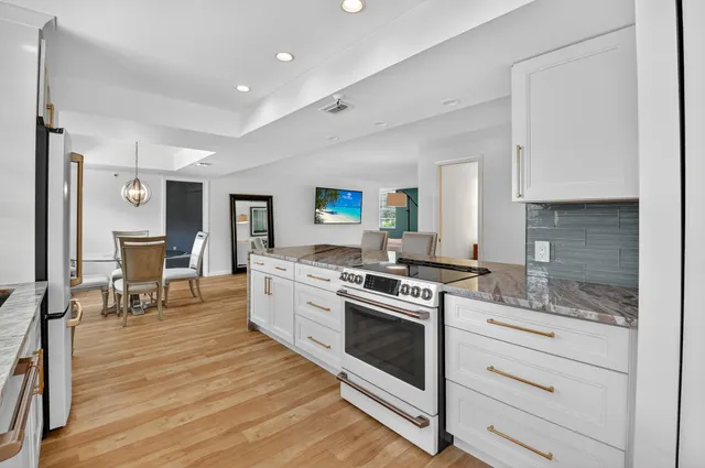 a kitchen with stainless steel appliances granite countertop a stove and a sink