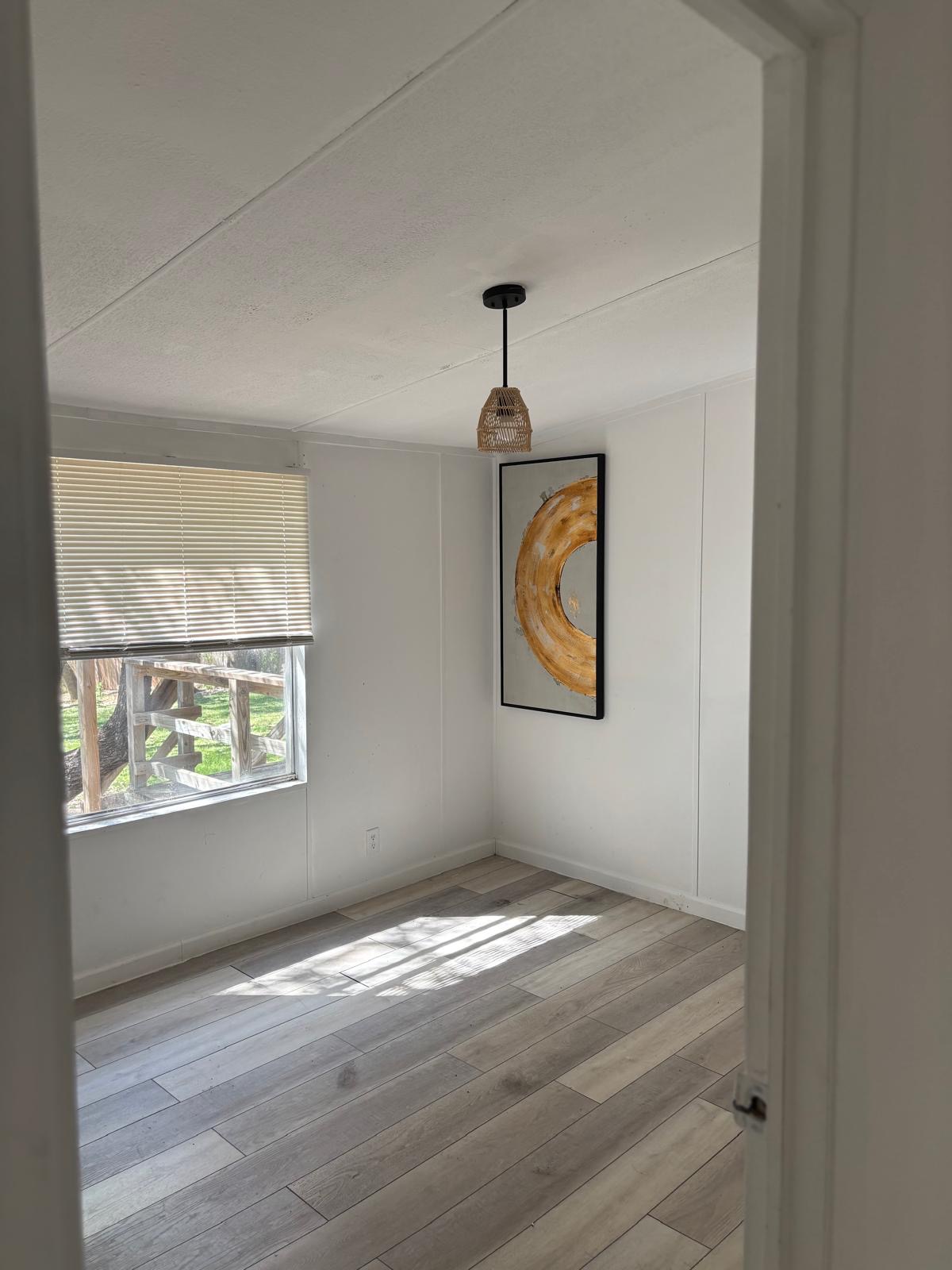 1109 Hurst Creek Road Austin, TX 78734 - Photo 13 of 18 Spare room with light wood finished floors and a decorative wall