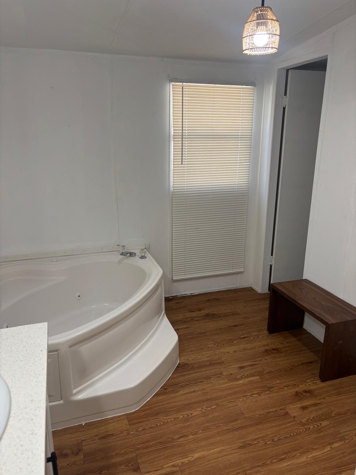 1109 Hurst Creek Road Austin, TX 78734 - Photo 15 of 18 Full bath with vanity, dark wood finished floors, and a jetted tub