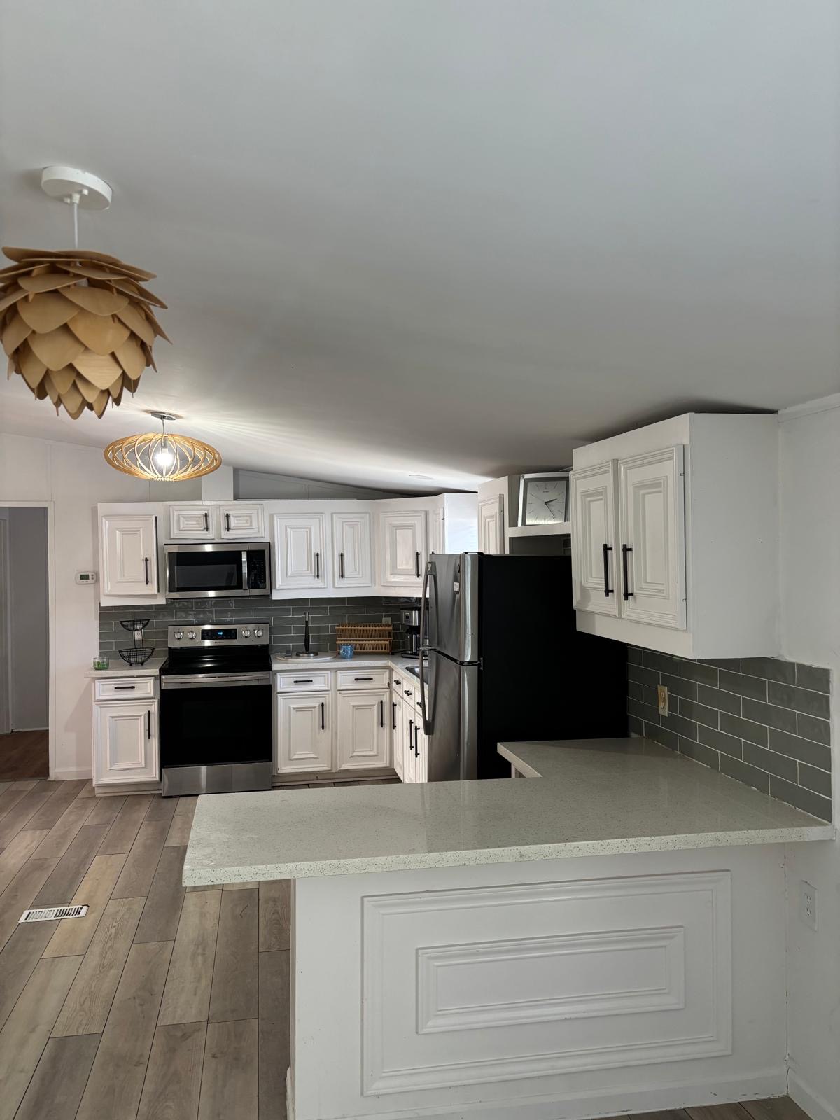 1109 Hurst Creek Road Austin, TX 78734 - Photo 18 of 18 Kitchen with tasteful backsplash, white cabinets, stainless steel appliances, light wood-type flooring, and vaulted ceiling