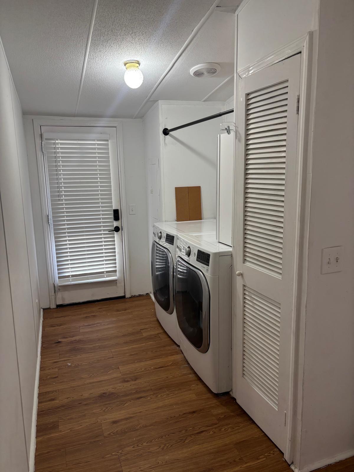 1109 Hurst Creek Road Austin, TX 78734 - Photo 10 of 18 Laundry area with dark wood finished floors, washer and dryer, and a textured ceiling