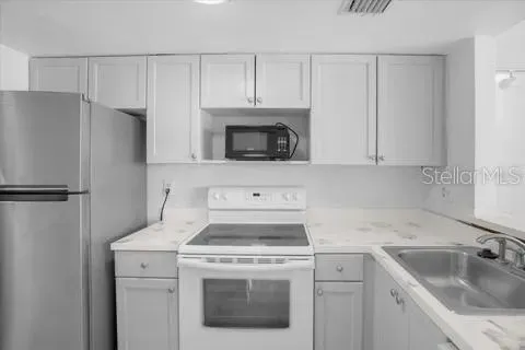 a kitchen with a sink stove and refrigerator