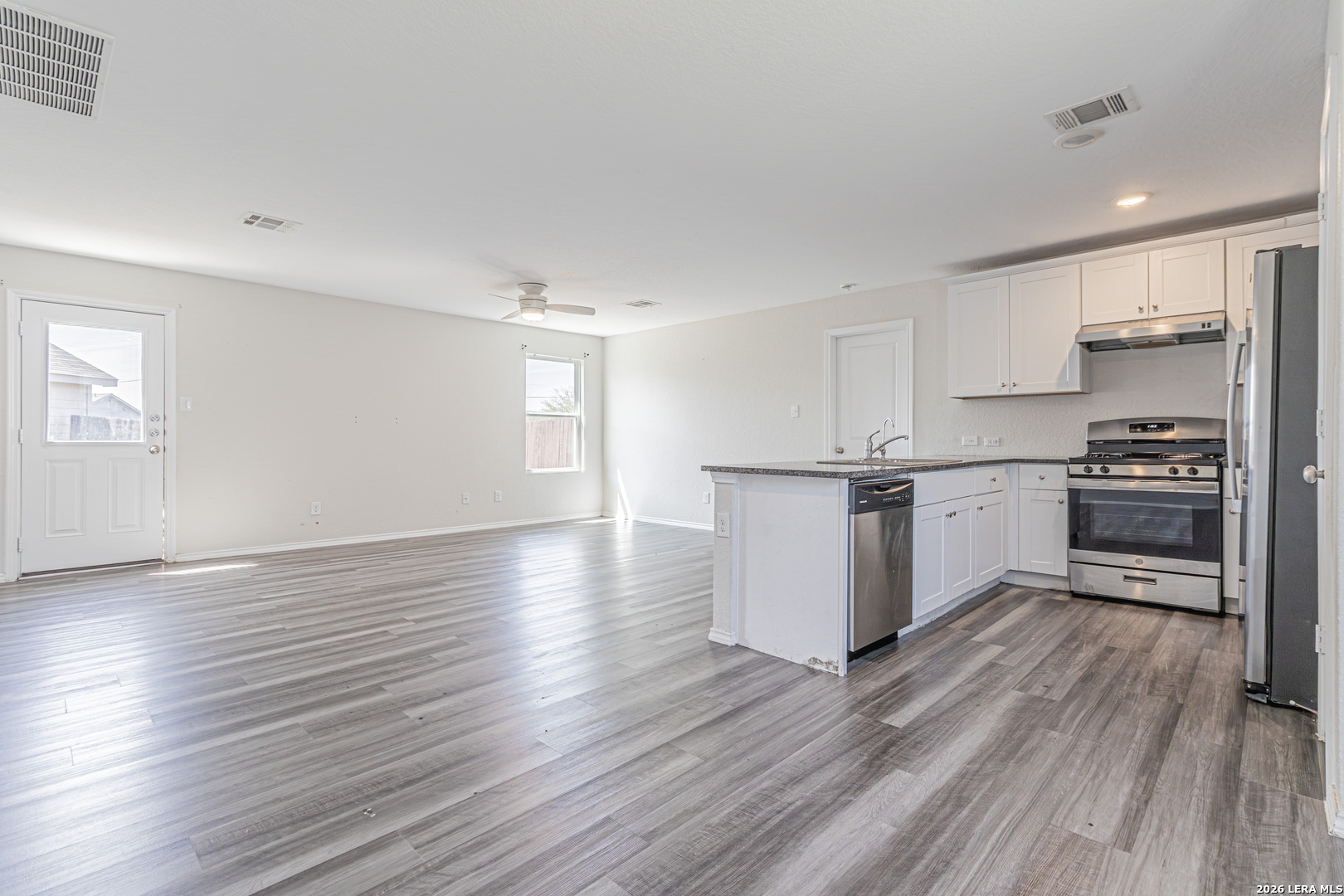 3814 Pickles Way Converse, TX 78109 - Photo 11 of 27 a kitchen with granite countertop wooden floors appliances and cabinets