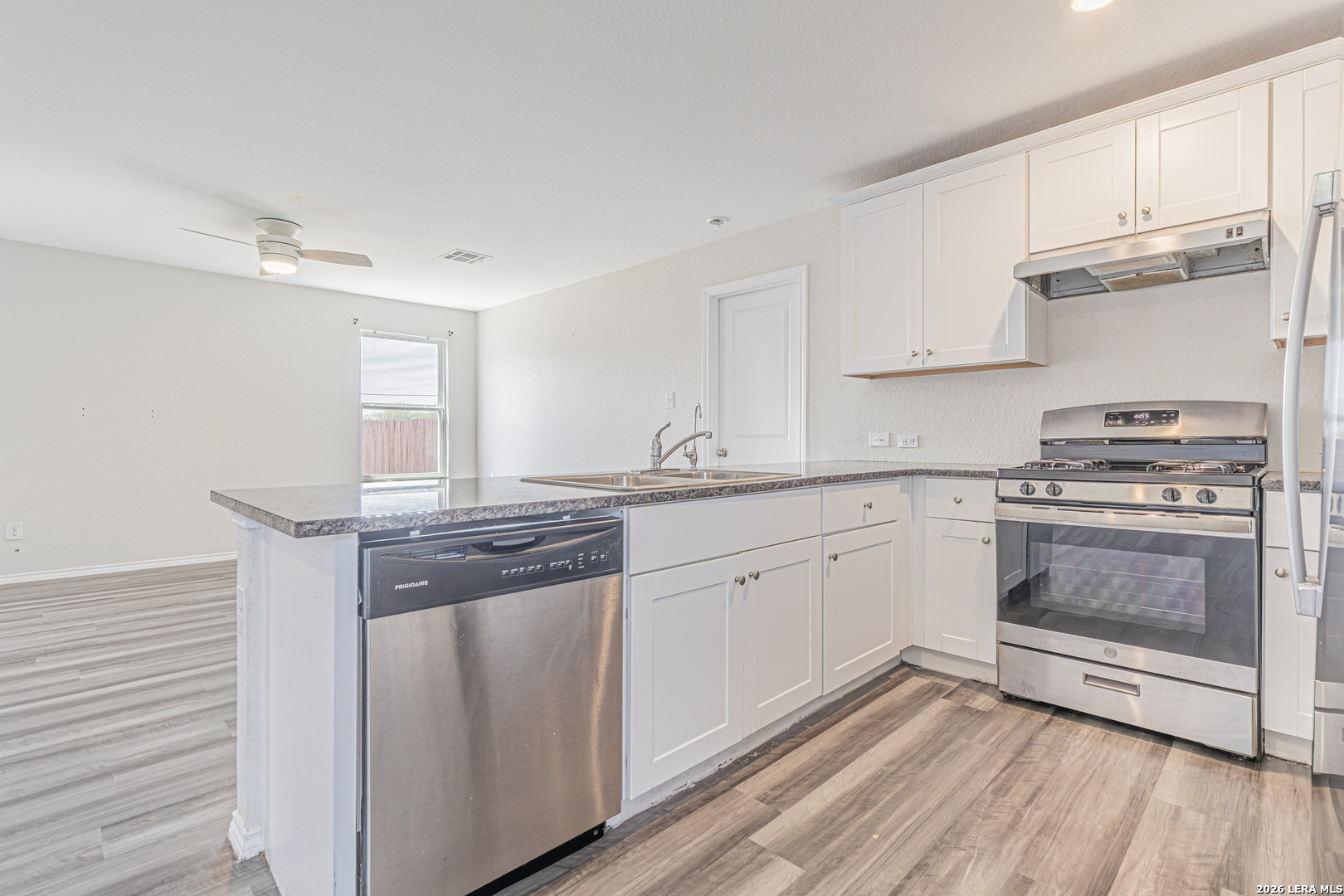 3814 Pickles Way Converse, TX 78109 - Photo 14 of 27 a kitchen with granite countertop cabinets stainless steel appliances and wooden floor