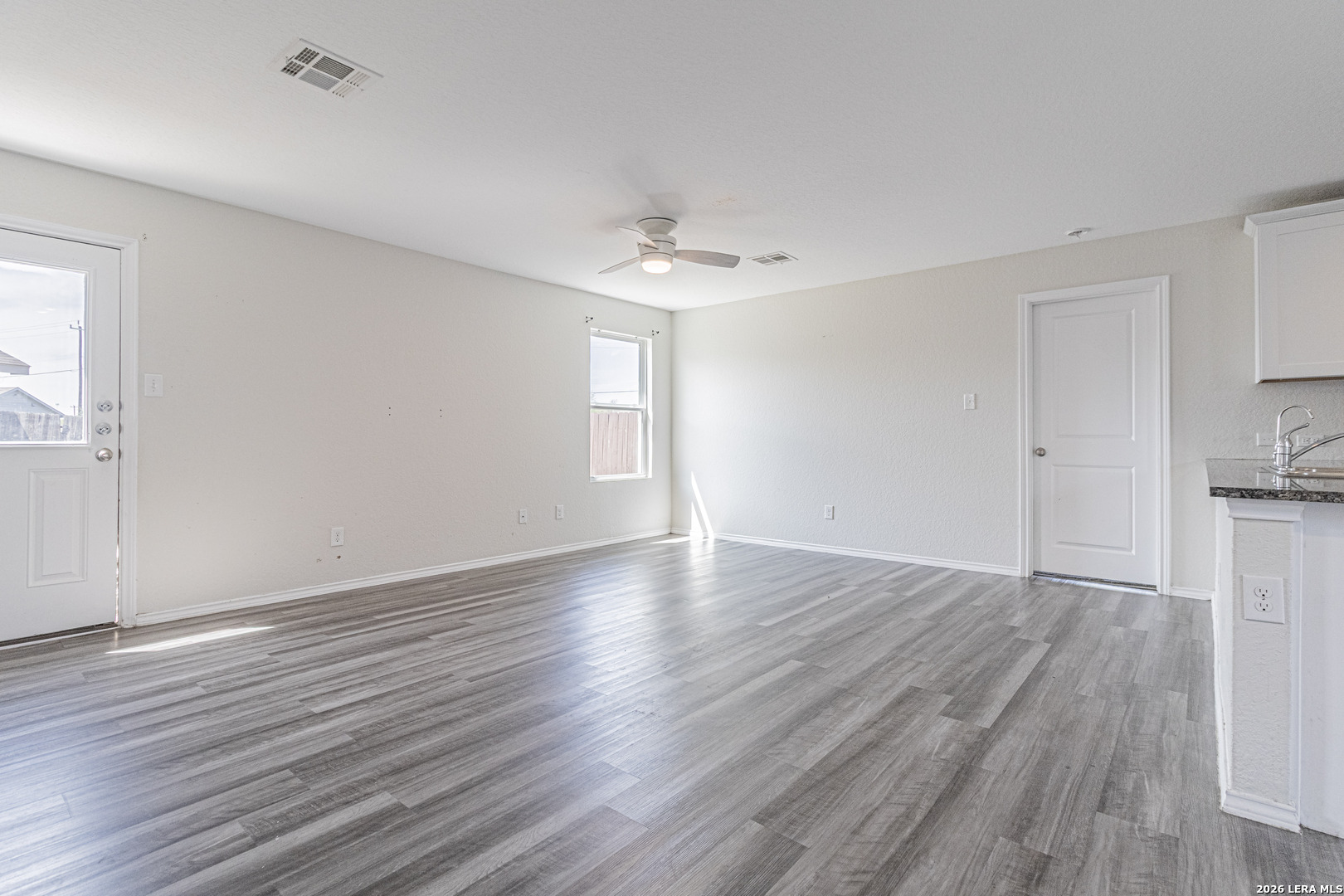 3814 Pickles Way Converse, TX 78109 - Photo 4 of 27 a view of an empty room with window and wooden floor