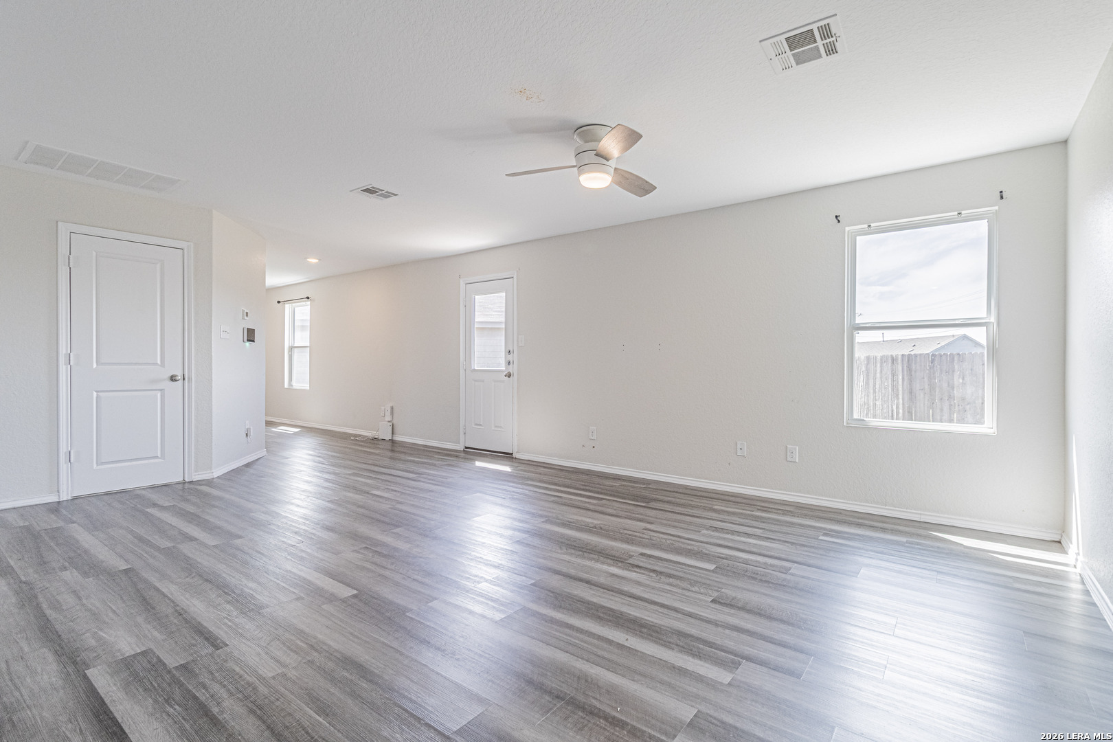 3814 Pickles Way Converse, TX 78109 - Photo 5 of 27 an empty room with wooden floor and windows