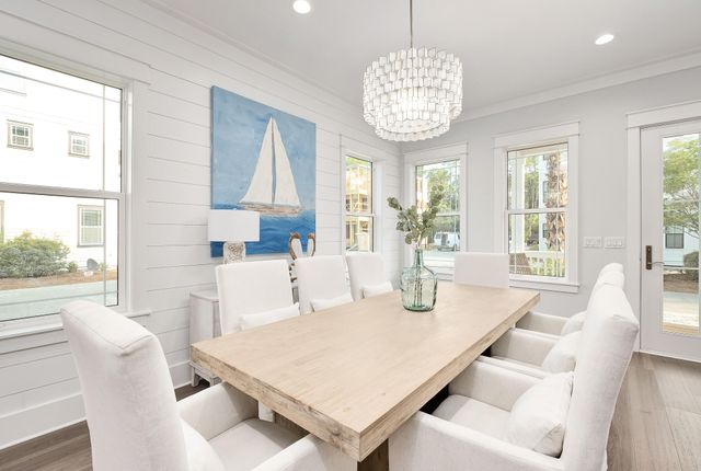 a view of a dining room with furniture a chandelier and wooden floor
