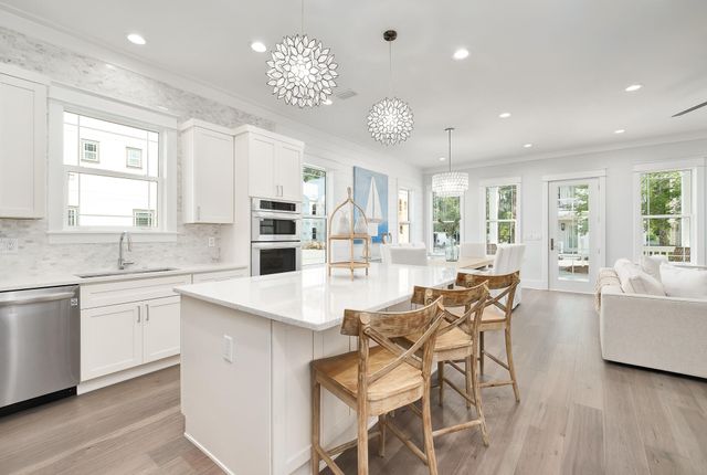 a kitchen with a dining table chairs cabinets and stainless steel appliances
