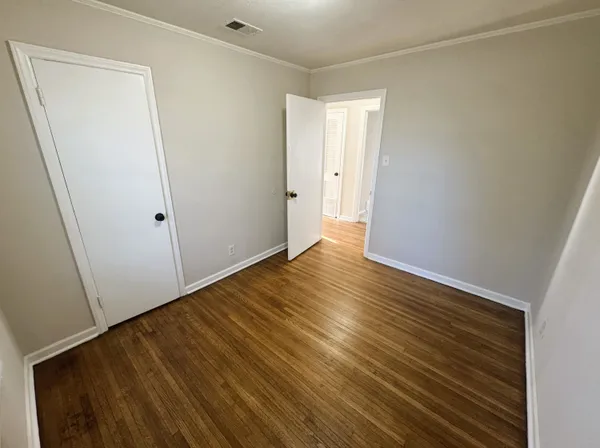 a view of an empty room with wooden floor