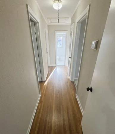 a view of a hallway with wooden floor and staircase