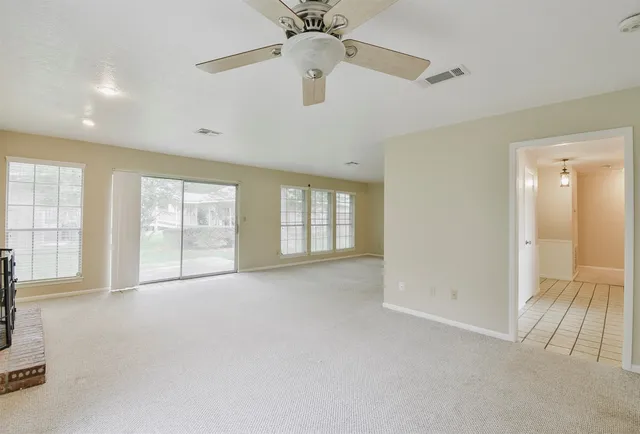 a kitchen with white cabinets and window