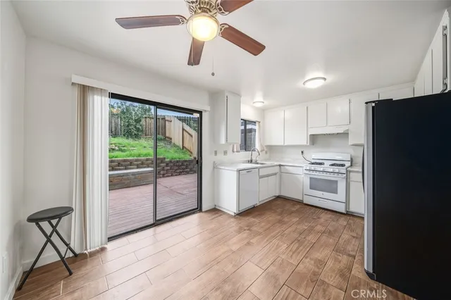 a kitchen with white cabinets and white appliances