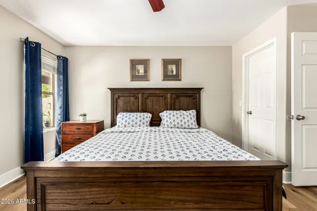 a bedroom with a bed and wooden floor