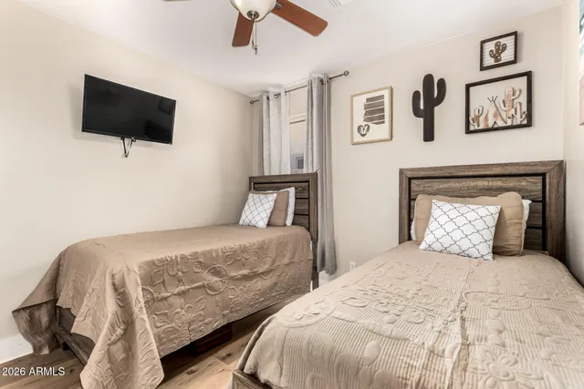 a bedroom with two bed and a flat screen tv