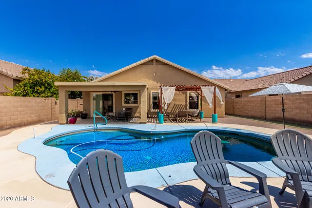 a view of a house with pool and chairs