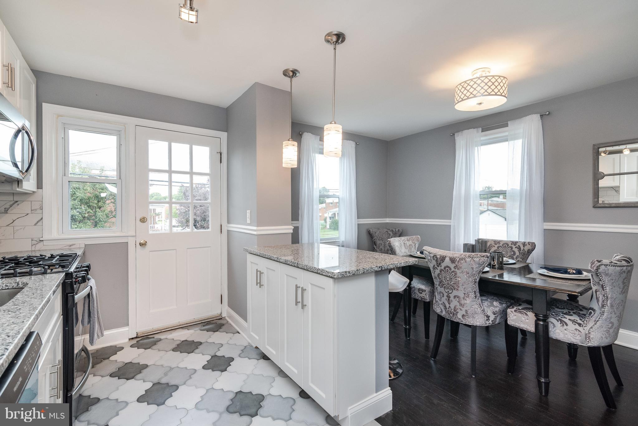 700 Aldworth Road Baltimore, MD 21222 - Photo 10 of 30 a open kitchen with stainless steel appliances granite countertop a stove a sink dishwasher a dining table and chairs with wooden floor