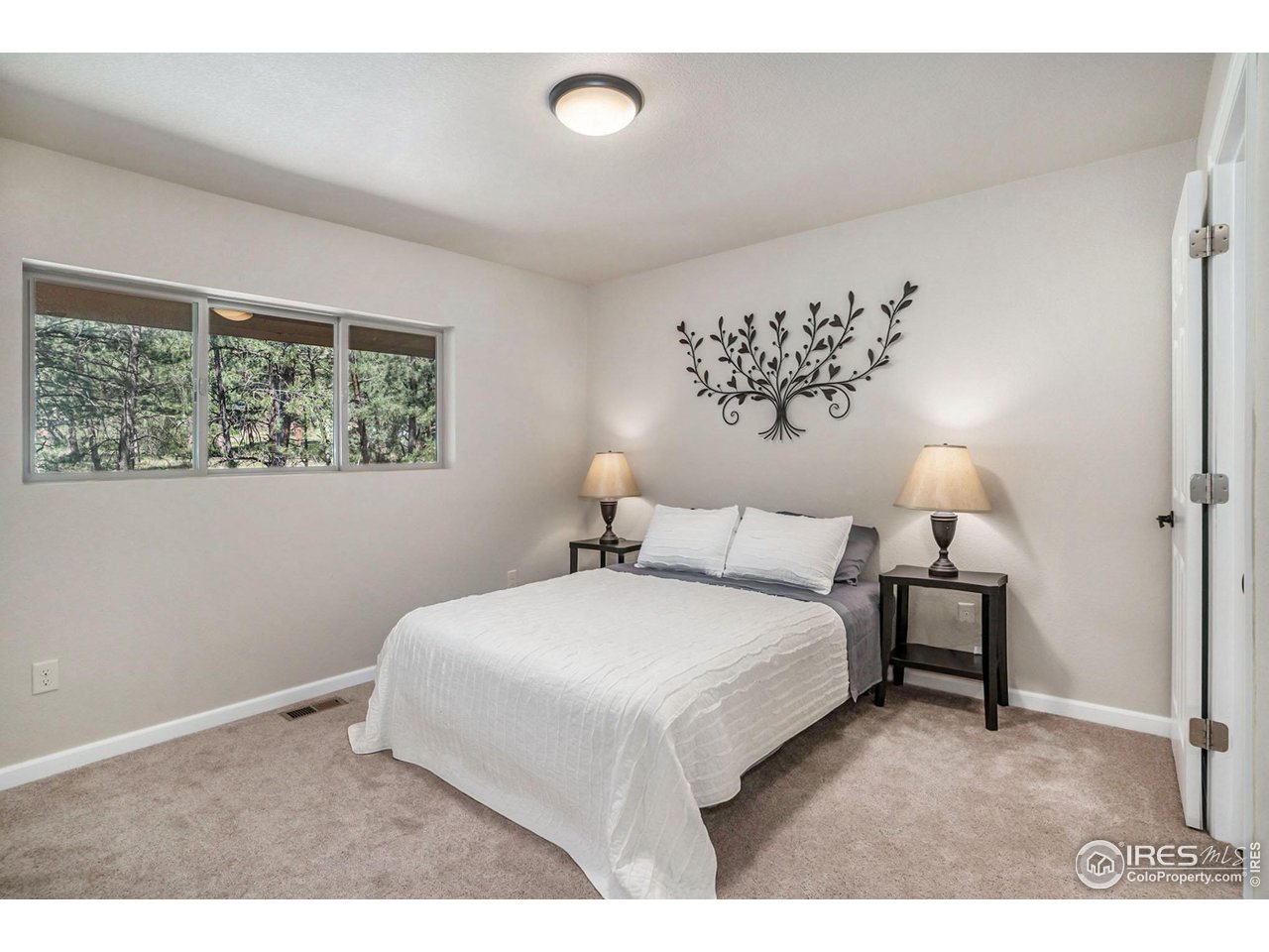 372 Cherokee Road Lyons, CO 80540 - Photo 11 of 33 a bedroom with a bed and a lamp