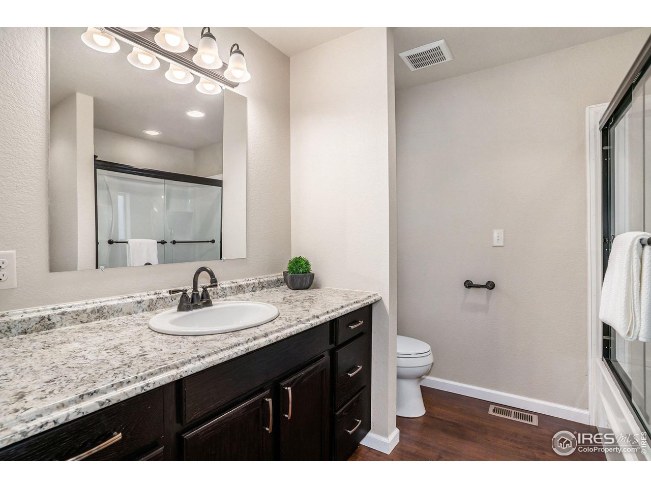 372 Cherokee Road Lyons, CO 80540 - Photo 13 of 33 a bathroom with a granite countertop sink a toilet a large mirror and shower