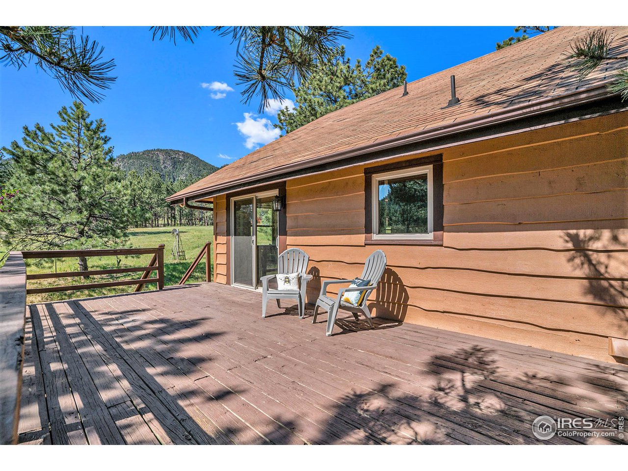 372 Cherokee Road Lyons, CO 80540 - Photo 21 of 33 a view of a patio with table and chairs with wooden floor and fence