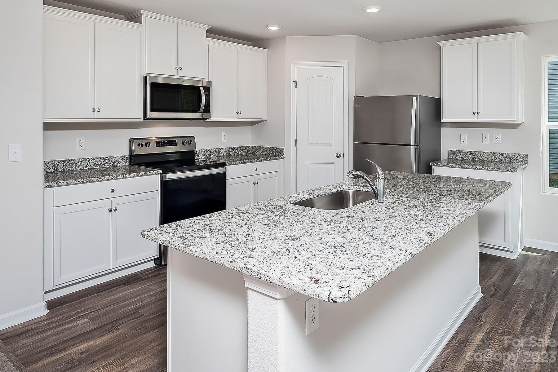 1341 Nia Road Charlotte, NC 28215 - Photo 3 of 15 a kitchen with kitchen island granite countertop stainless steel appliances microwave stove refrigerator and sink