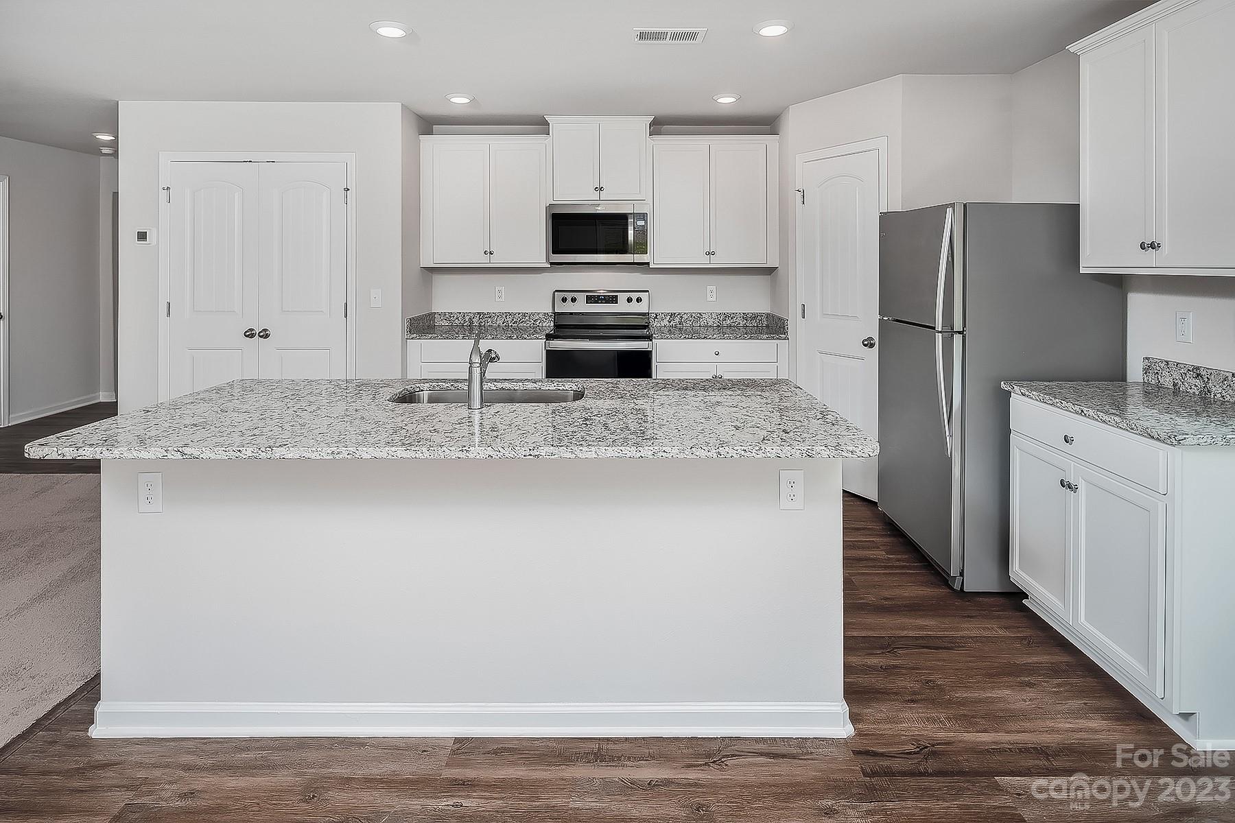 1341 Nia Road Charlotte, NC 28215 - Photo 5 of 15 a kitchen with stainless steel appliances granite countertop a refrigerator a stove a sink and white cabinets