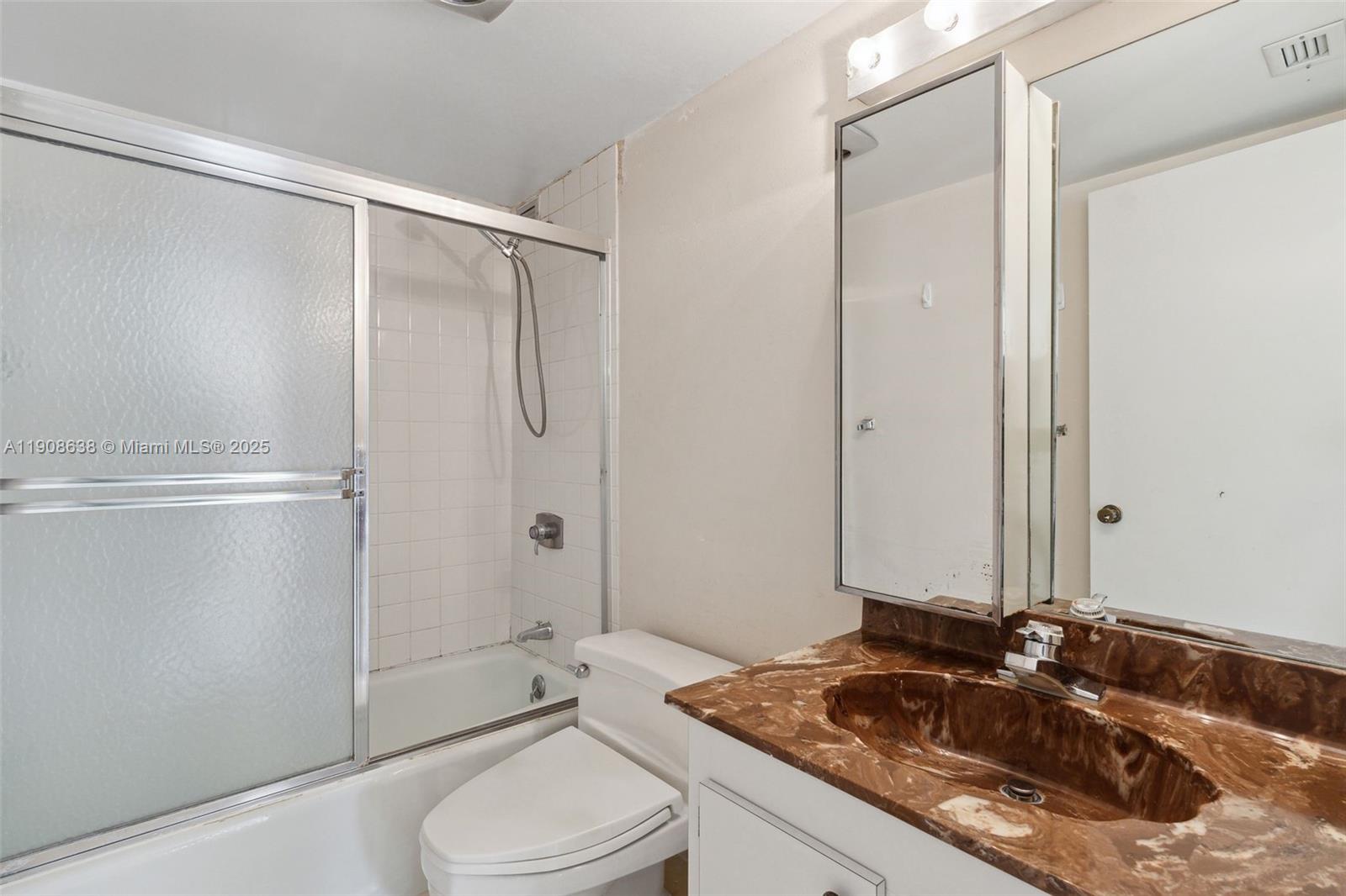 1901 Brickell Avenue, Unit B1408 Miami, FL 33129 - Photo 22 of 37 a bathroom with a granite countertop sink toilet and shower