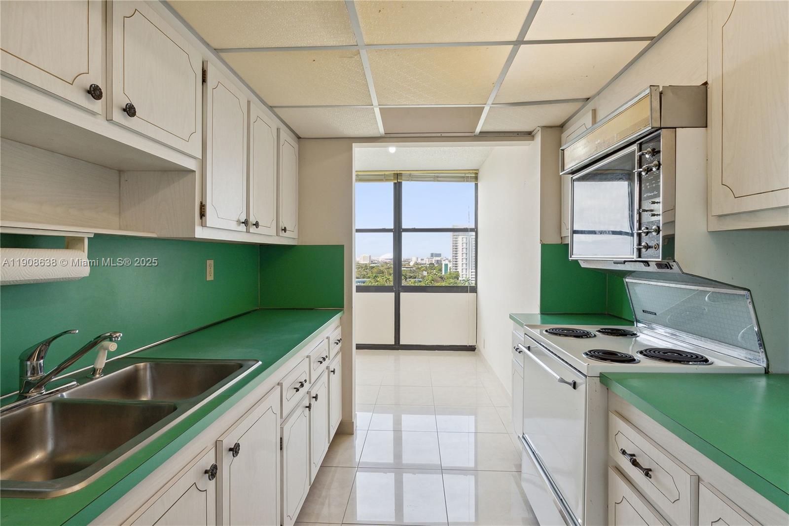 1901 Brickell Avenue, Unit B1408 Miami, FL 33129 - Photo 6 of 37 a kitchen with a sink cabinets and window