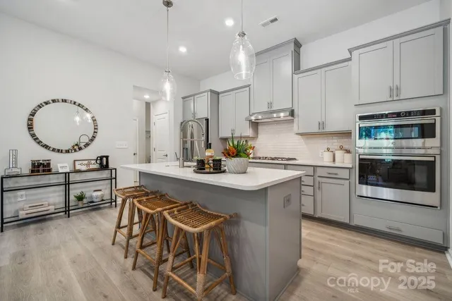 a kitchen with stainless steel appliances a sink stove and cabinets