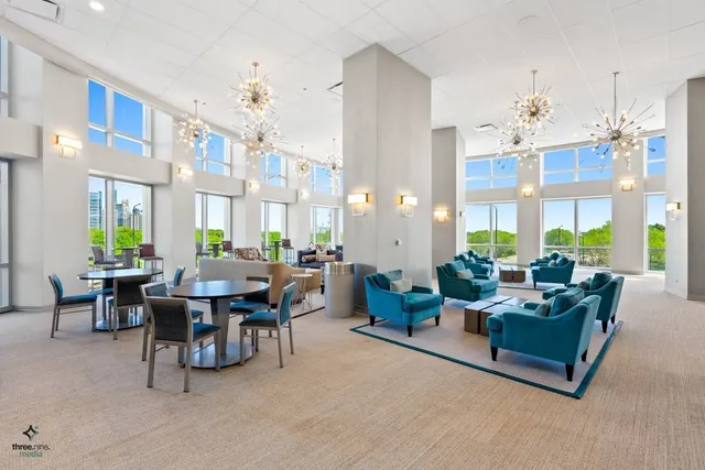 a living room with furniture a chandelier and a dining table