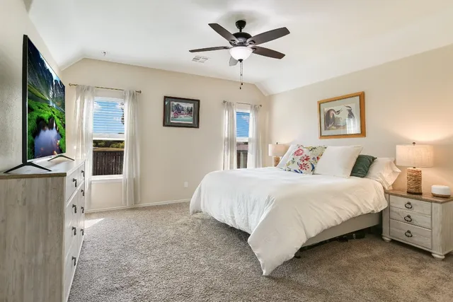 a spacious bedroom with a bed and a chandelier