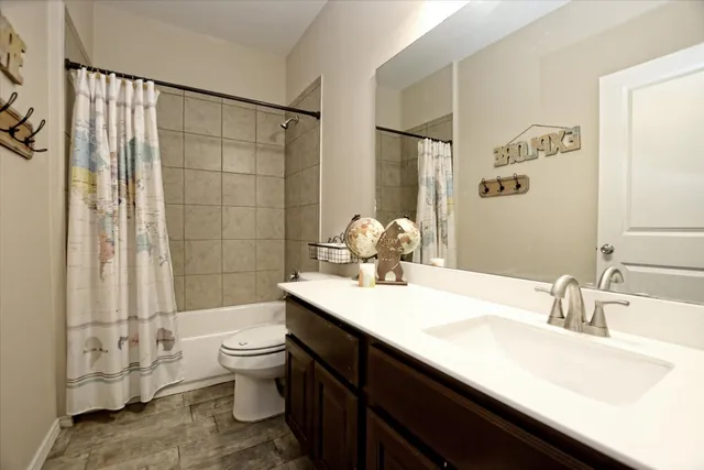 a bathroom with a double vanity sink toilet and shower