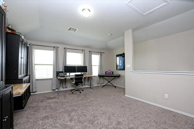 a view of a workspace with furniture and a window