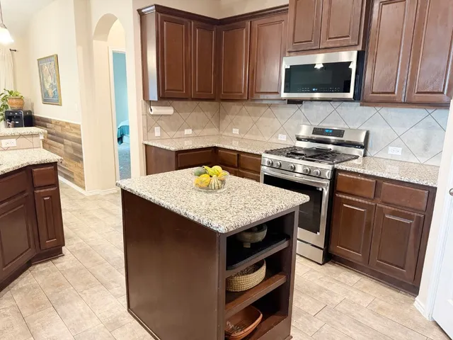 a kitchen with a stove a sink and a microwave