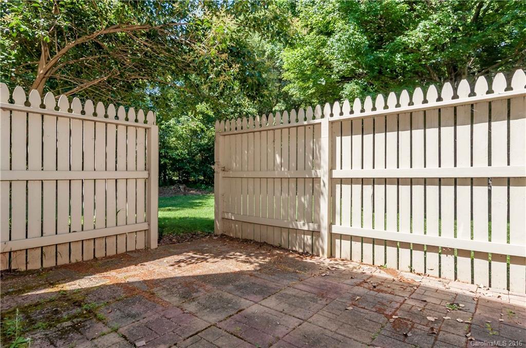5945 Quail Hollow Road, Unit A Charlotte, NC 28210 - Photo 17 of 19 a view of a small yard with wooden fence and trees
