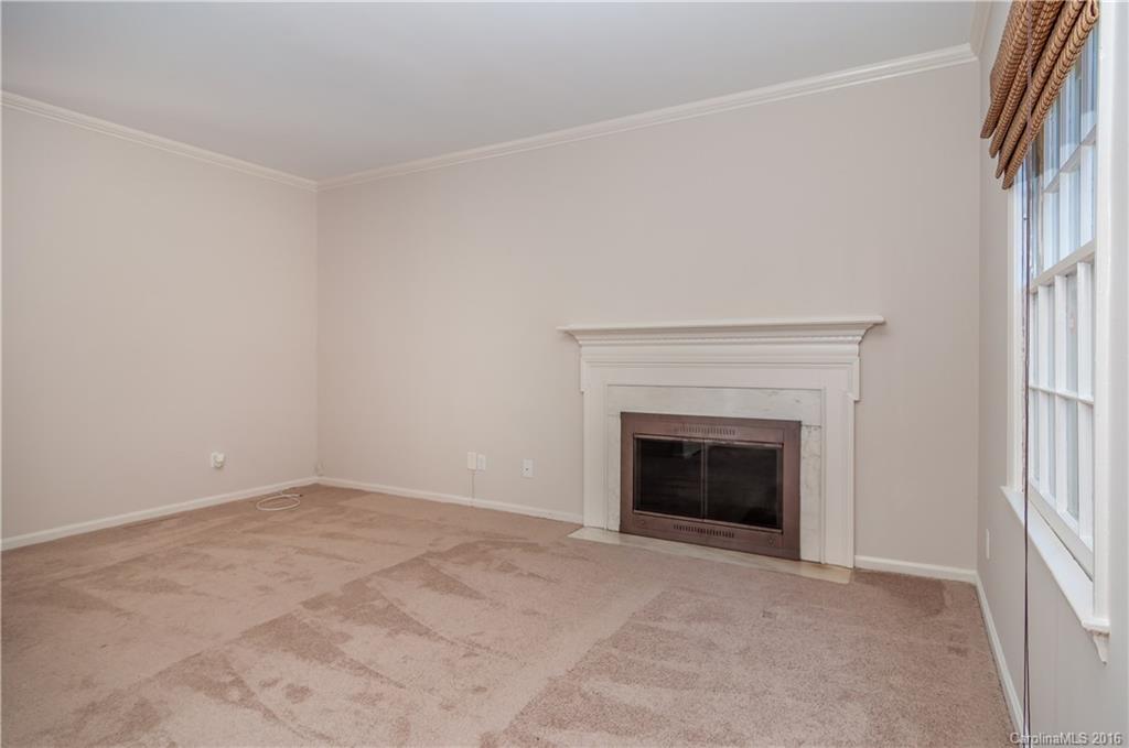 5945 Quail Hollow Road, Unit A Charlotte, NC 28210 - Photo 3 of 19 an empty room with a fireplace and a window