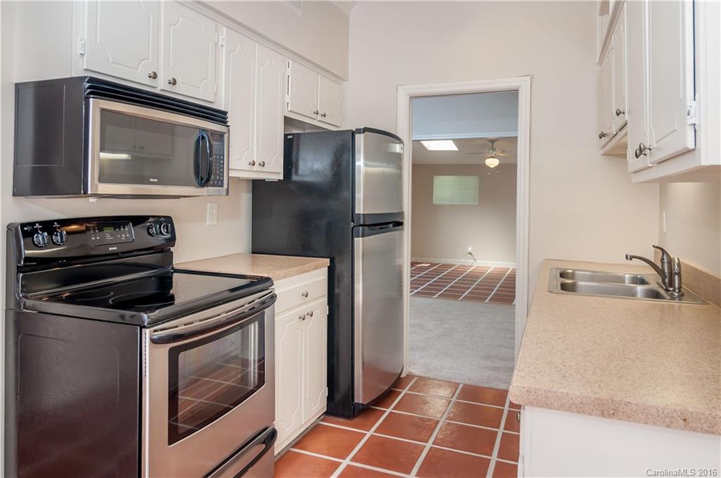 5945 Quail Hollow Road, Unit A Charlotte, NC 28210 - Photo 6 of 19 a kitchen with granite countertop a stove and a microwave