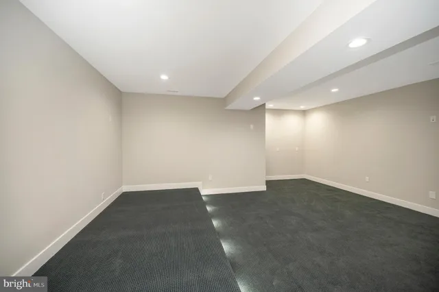 an empty room with wooden floor and ceiling fan