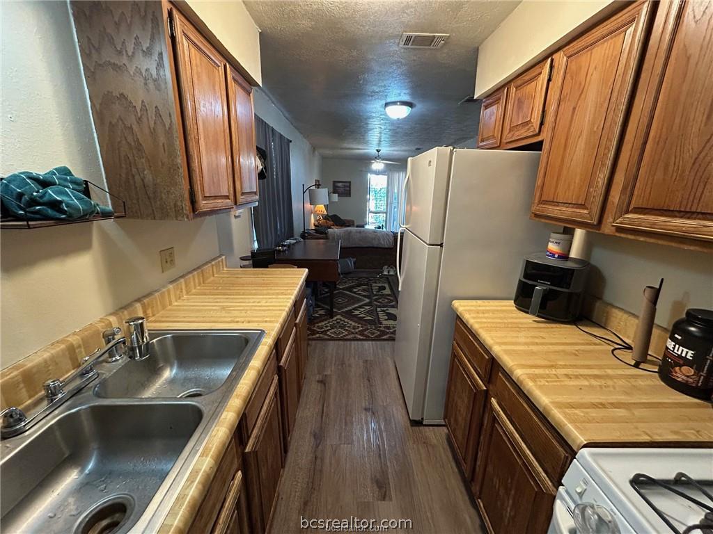 1504 Pine Ridge Drive, Unit A College Station, TX 77840 - Photo 6 of 15 a kitchen with a sink stove and refrigerator