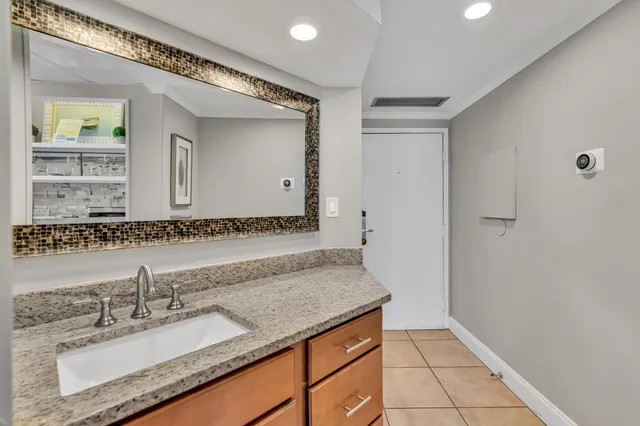 a bathroom with a granite countertop sink and a mirror