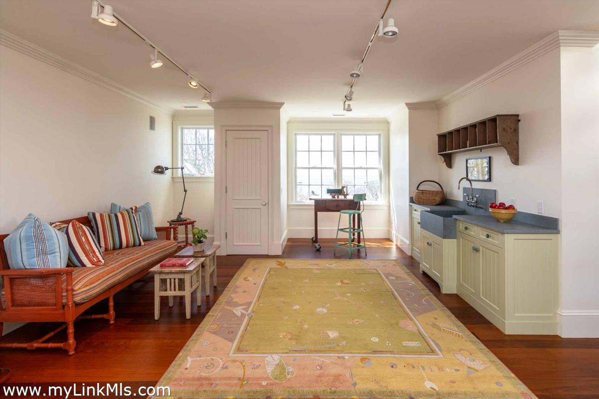 25 Lelands Path Edgartown, MA 02539 - Photo 29 of 56 a spacious bedroom with a bed a table in it and a large window