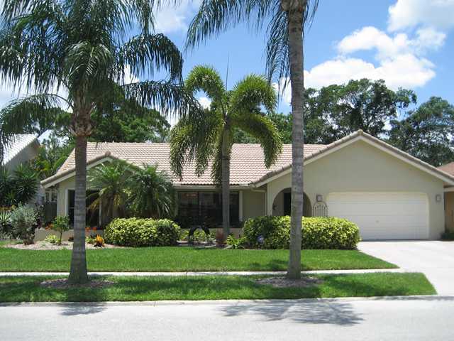 5038 Marina Circle Boca Raton, FL 33486 - Photo 1 of 19 a front view of a house with a garden