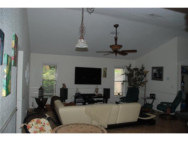5038 Marina Circle Boca Raton, FL 33486 - Photo 9 of 19 a living room with furniture a chandelier and a flat screen tv