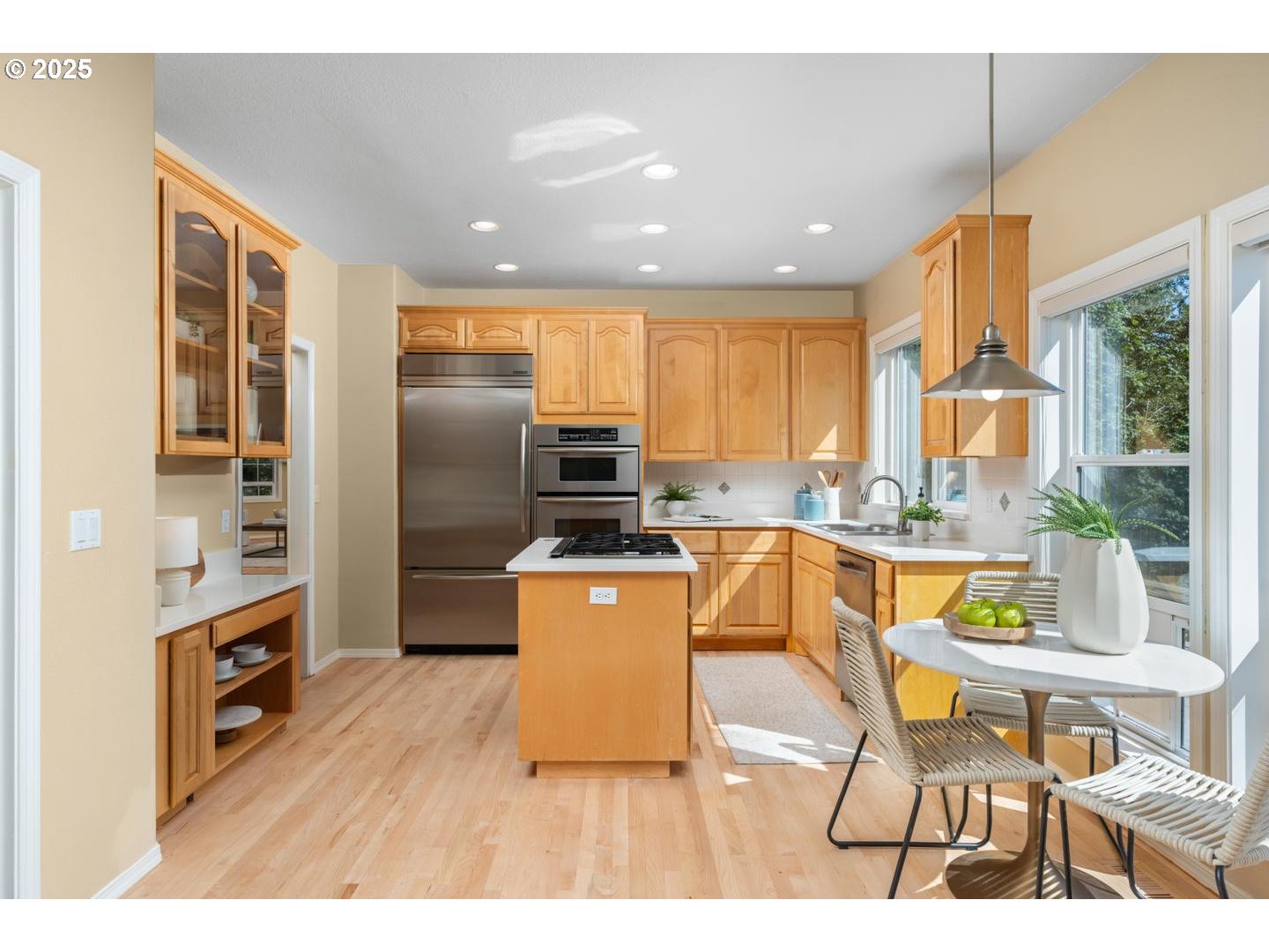 2118 Northwest Mill Pond Road Portland, OR 97229 - Photo 8 of 44 a kitchen with stainless steel appliances granite countertop a refrigerator a stove top oven and a dining table with wooden floor