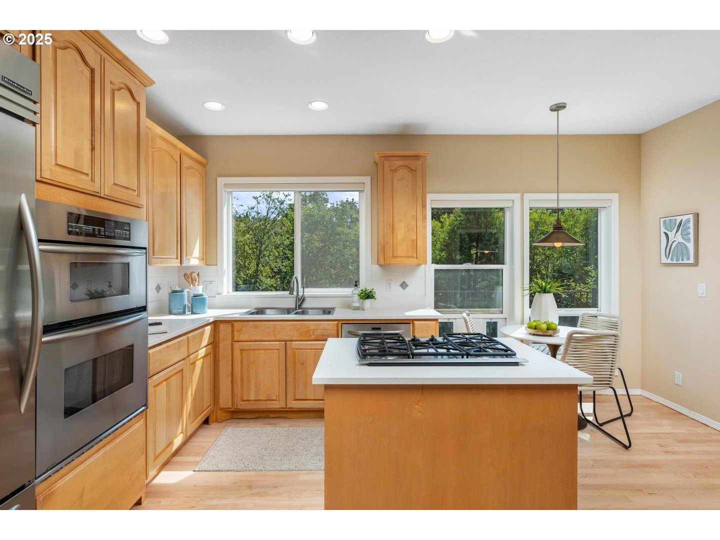 2118 Northwest Mill Pond Road Portland, OR 97229 - Photo 9 of 44 a kitchen with stainless steel appliances granite countertop a stove a sink dishwasher a microwave oven and a dining table with wooden cabinet