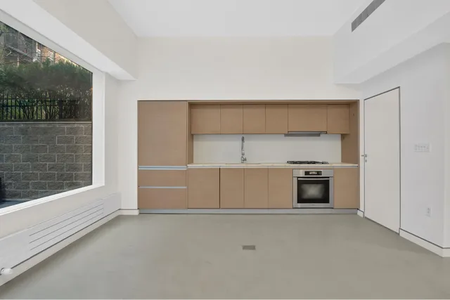 a view of kitchen and empty room with a fireplace