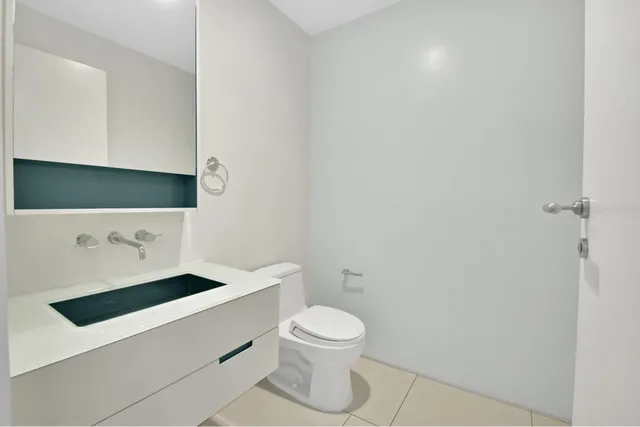 a bathroom with a toilet a sink and mirror