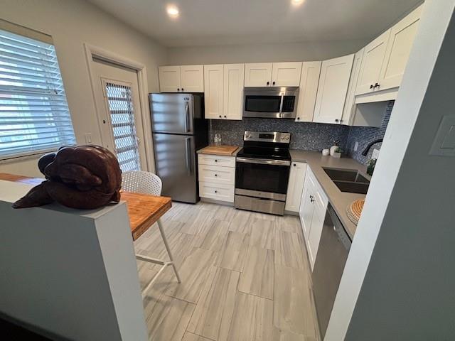 a kitchen with stainless steel appliances a refrigerator a stove a sink a microwave and cabinets